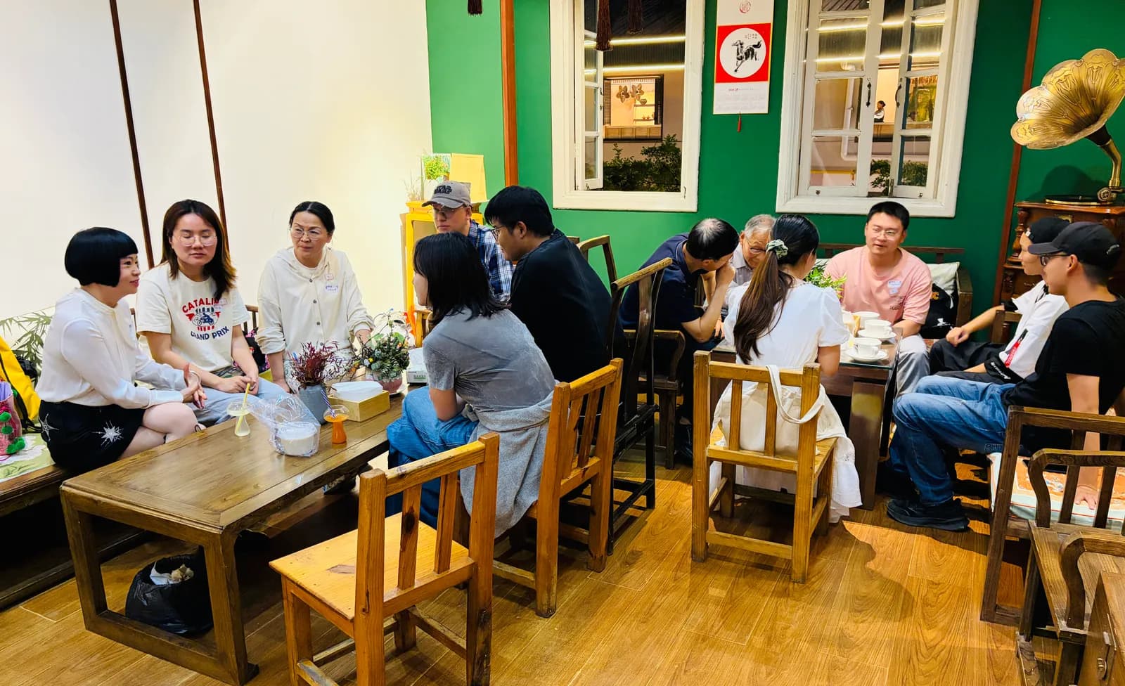 Conversation running at three separate tables across the tea house