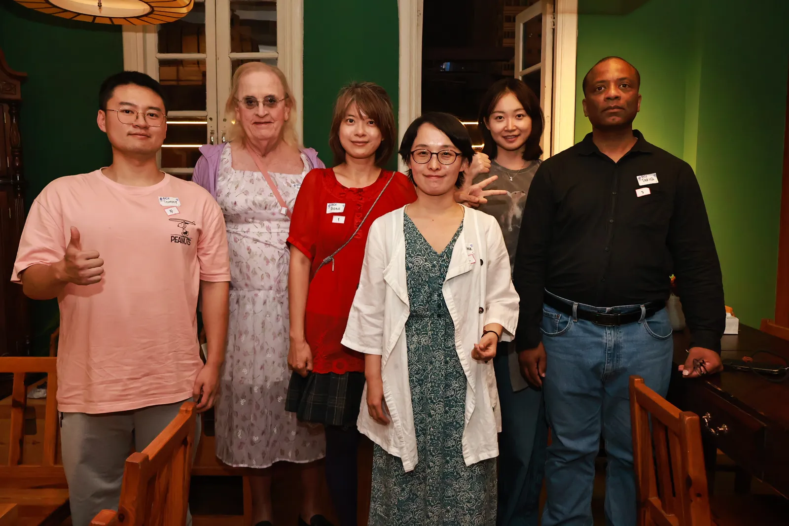 Six of us lined up for a photo in the green-walled tea house, name tags on