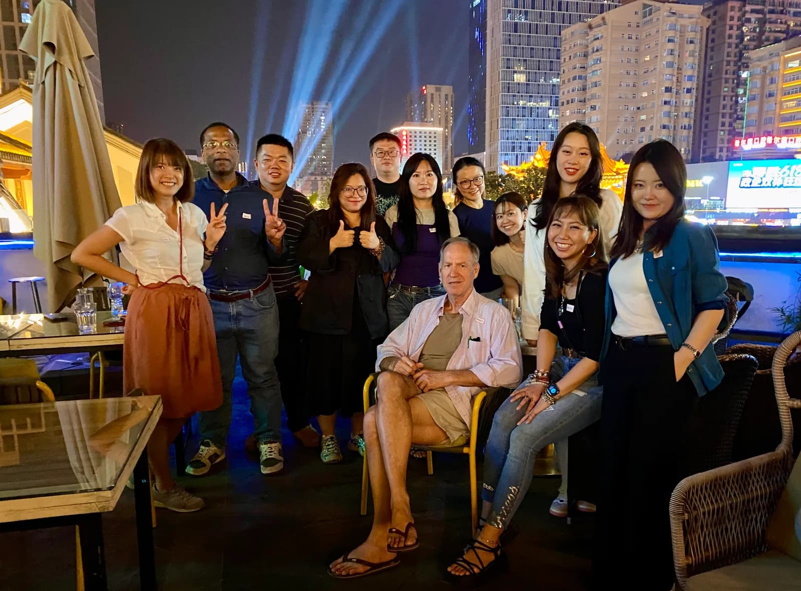 A rooftop meet-up at night, the city lit up behind us