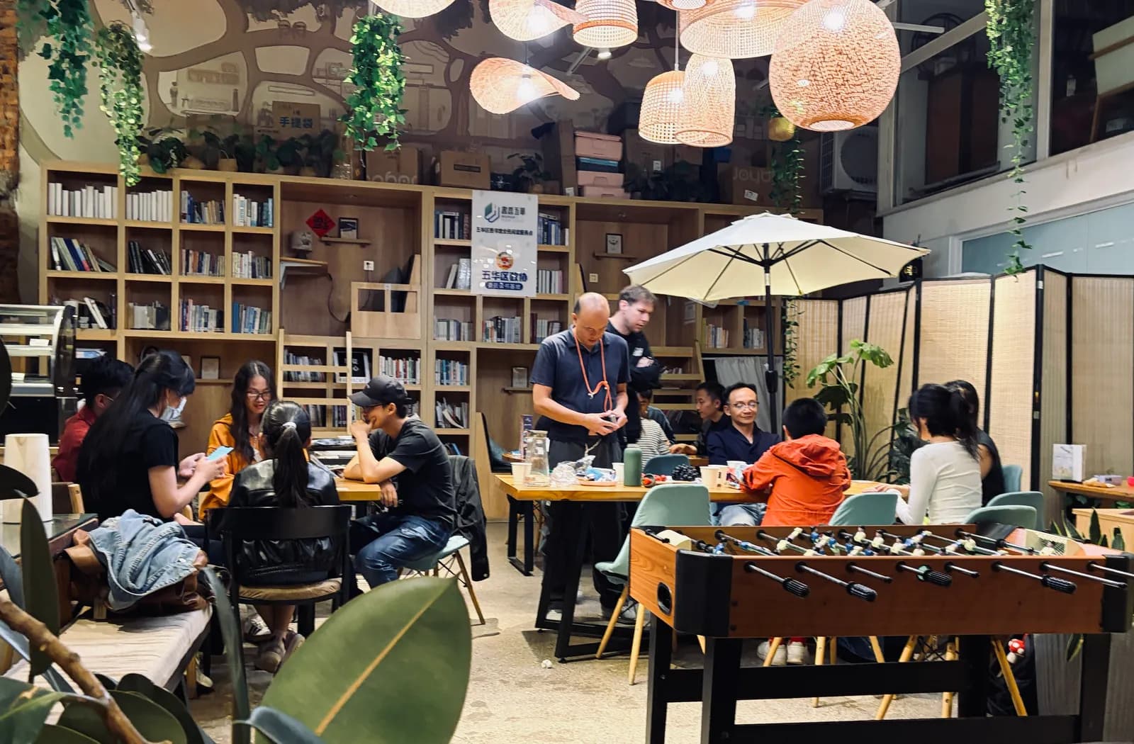 Two games running at once across the cafe, with bookshelves along the back wall