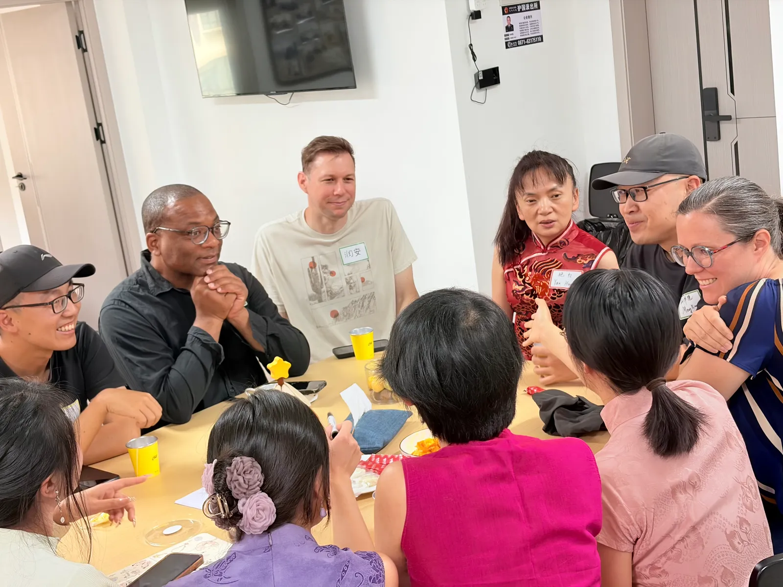 People crowded around one end of the table mid-conversation, name tags on